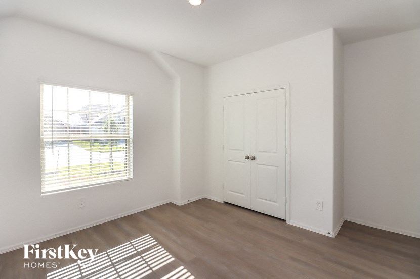 the living room of an apartment with a door and a window