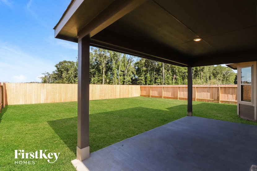 a patio with a lawn and a wooden fence