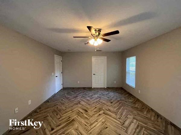 a empty room with a ceiling fan and a door