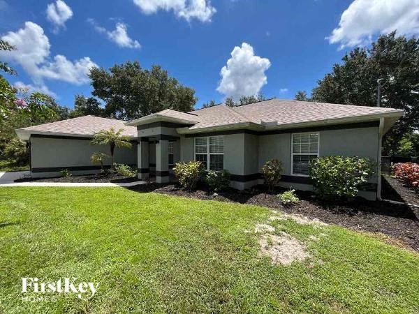 a green house with a lawn and trees