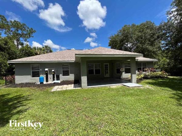 a small house with a grassy yard and trees