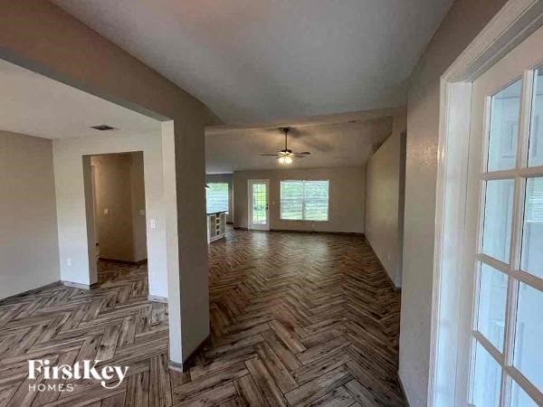 an empty living room with a checkered wood floor