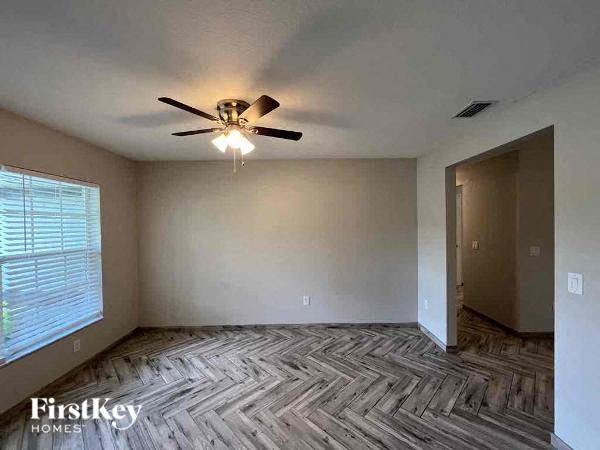 an empty room with a ceiling fan and a window