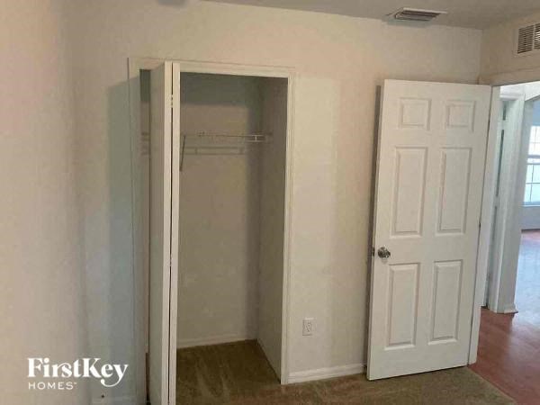 an empty room with a closet and a white door