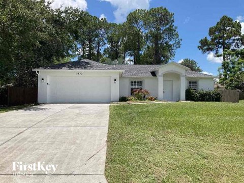 a white house with a yard and a garage