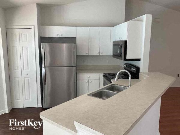a kitchen with a stainless steel refrigerator and a sink