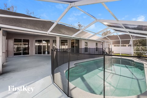 a swimming pool in the middle of a house with a glass fence