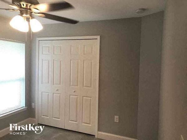 a bedroom with a ceiling fan and a white door