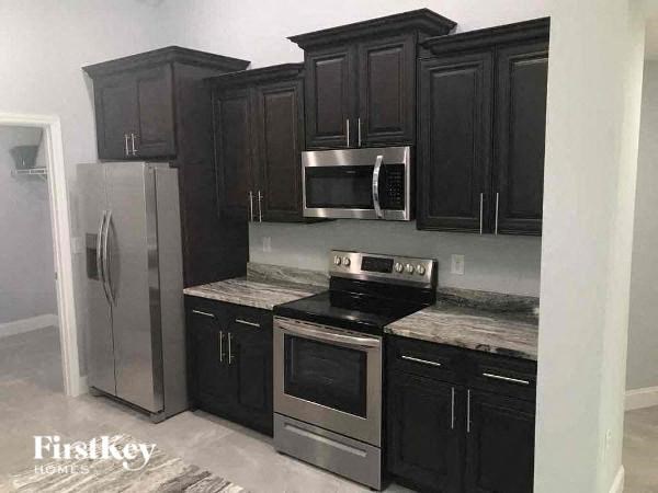 a kitchen with black cabinets and stainless steel appliances