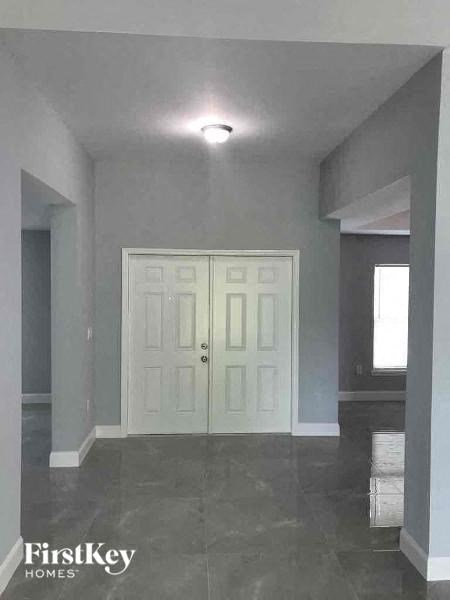 an empty room with a white door and tile floor