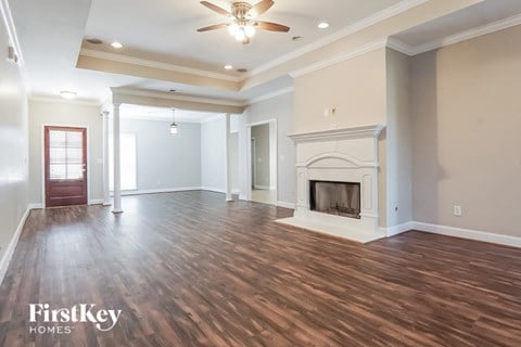 A spacious living room with wood flooring and a fireplace.