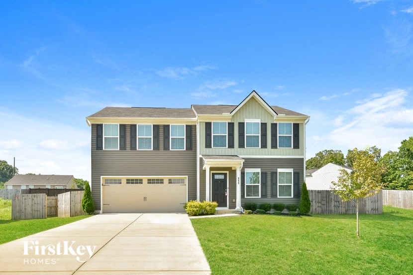 a house with a garage door and a lawn