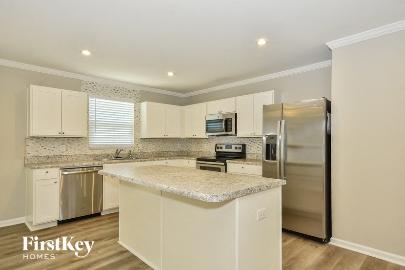a kitchen with white cabinets and a granite counter top