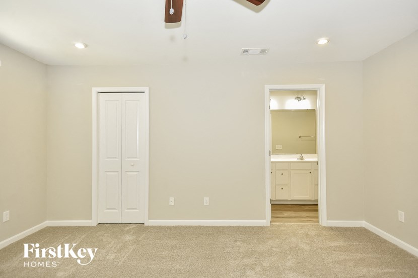an empty room with a closet and a door to a bathroom