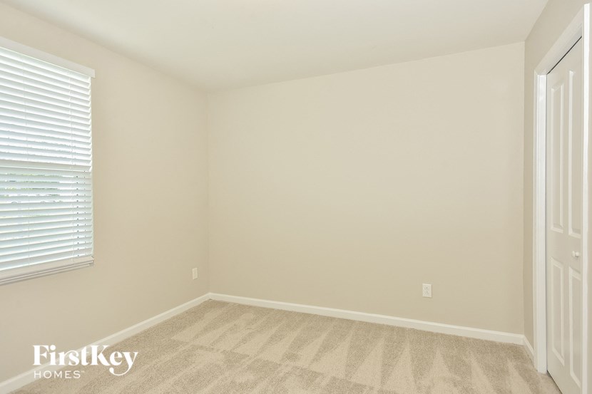 a bedroom with a carpeted floor and a window