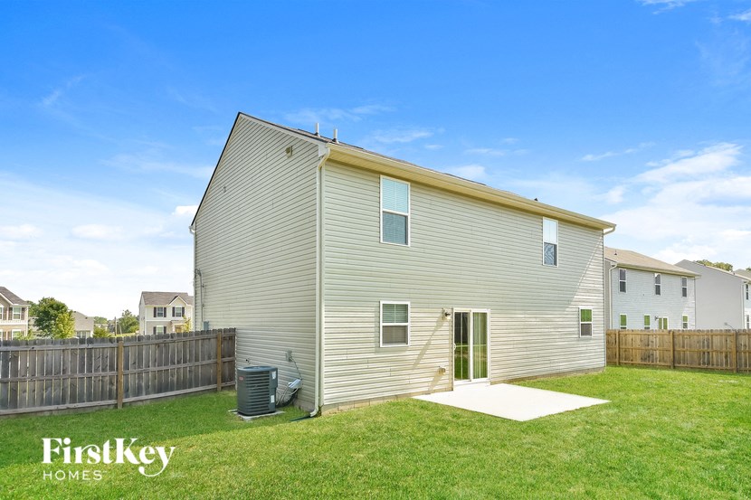 the backyard of a house with a yard and a wooden fence