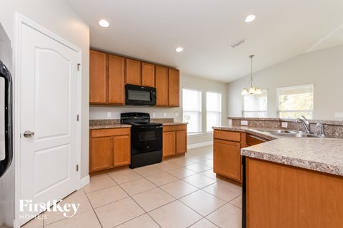 A kitchen with wooden cabinets and a black stove top oven.