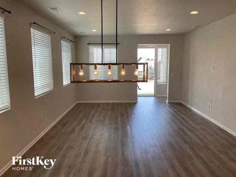 an empty living room with wood floors and a light fixture