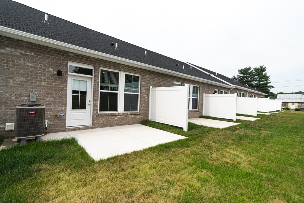 the front of a brick house with a porch and a grill