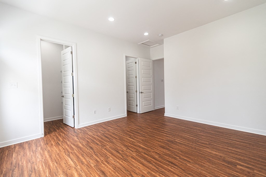 a living room with a hard wood floor and white walls
