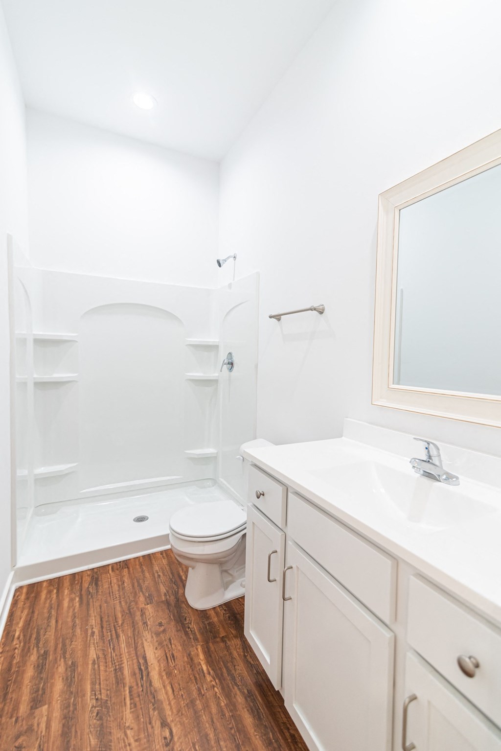a bathroom with white cabinets and a toilet and a shower