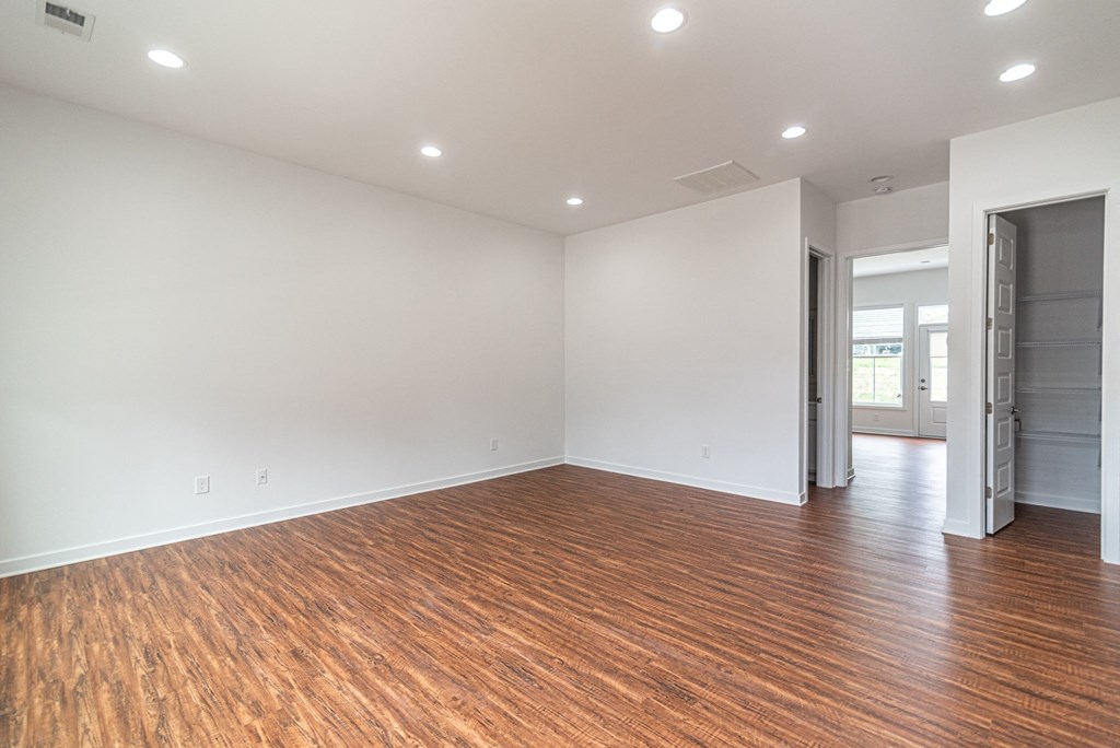 an empty living room with wood flooring and white walls
