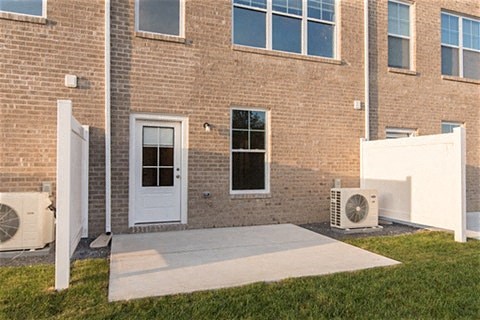a patio in front of a brick building with a white door
