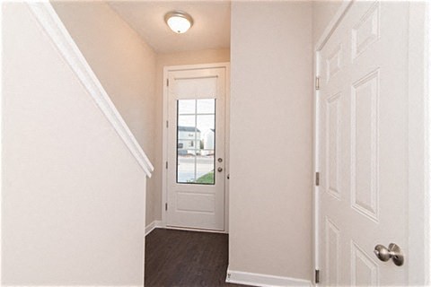 a hallway with a white door and a door to a white room