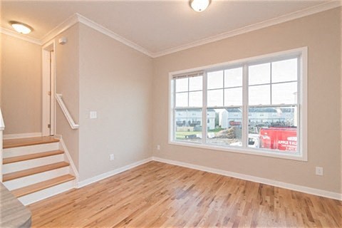 an empty living room with a large window and wooden floors