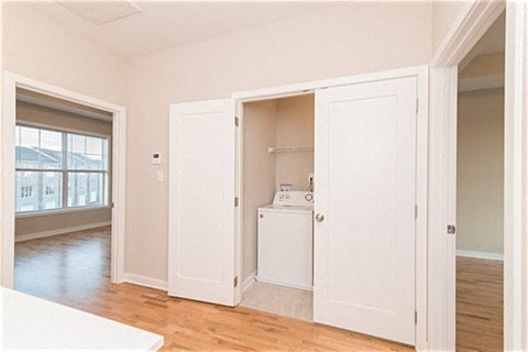 an empty room with white doors and a laundry room