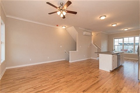 an empty living room and kitchen with a ceiling fan