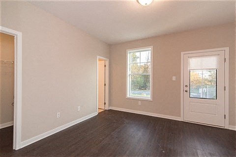 an empty living room with a door and a window