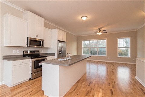 an empty kitchen with white cabinets and a counter top