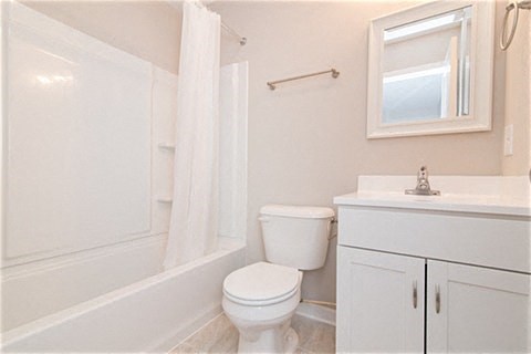 a bathroom with a toilet and a tub and a sink