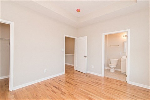 a empty living room with a toilet and a door to a bathroom