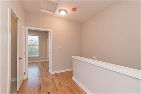 a empty room with a white wall and wooden floors