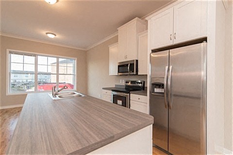a kitchen with a stainless steel refrigerator and a sink