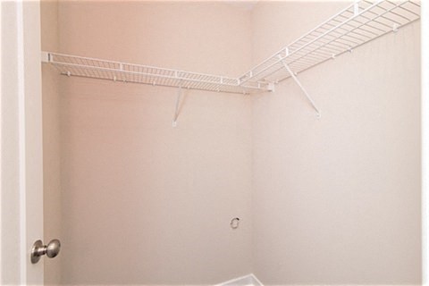 a white bathroom with a shower and a rack on the wall