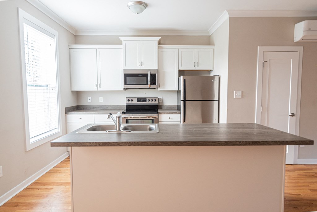 a kitchen with white cabinets and a granite counter top