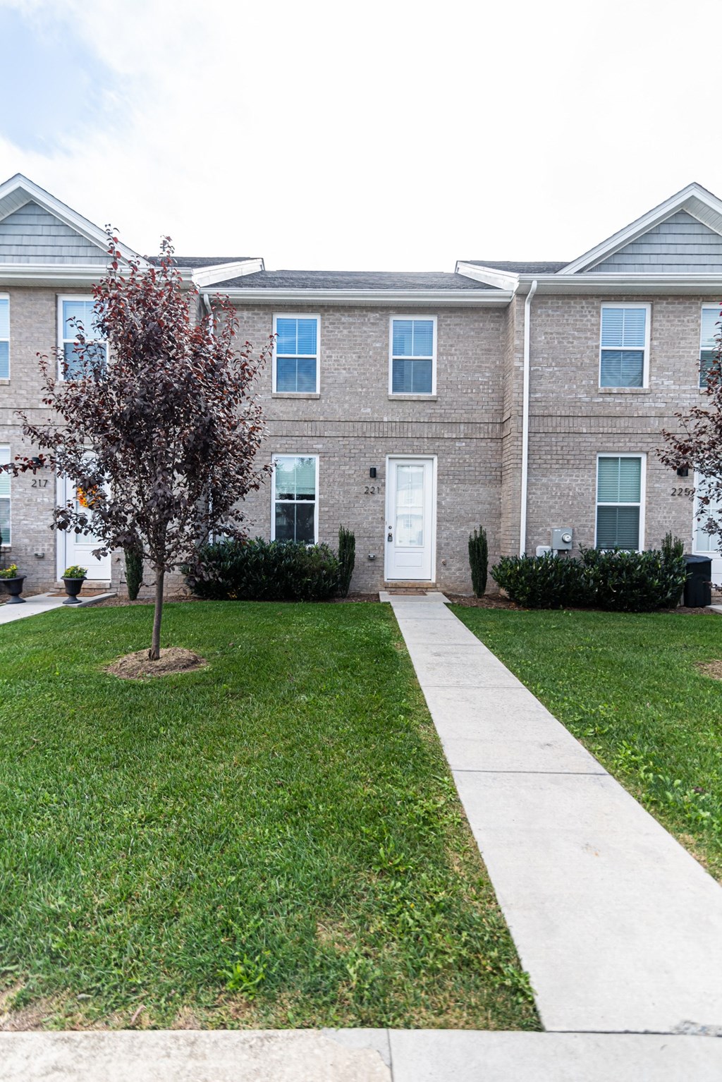 an apartment building with a sidewalk in front of it