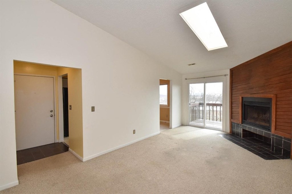 a living room with a fireplace and a door to a balcony