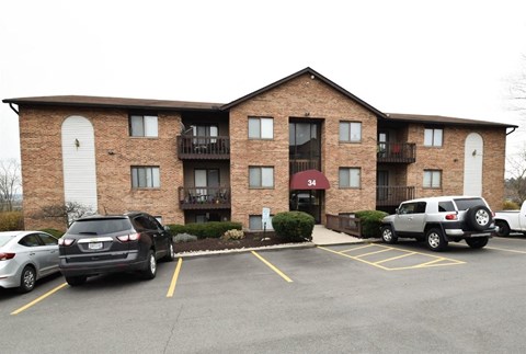 an apartment building with cars parked in a parking lot