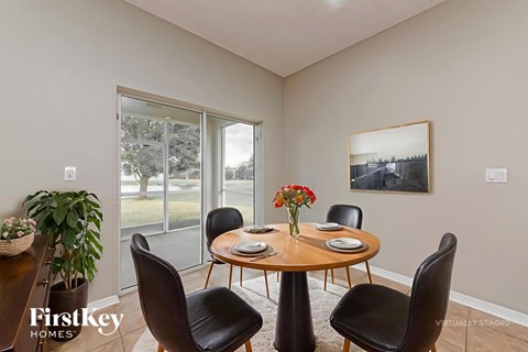 A dining room with a round table and chairs.
