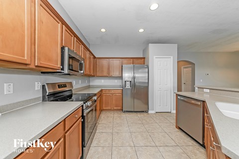 A kitchen with wooden cabinets and a stainless steel refrigerator.