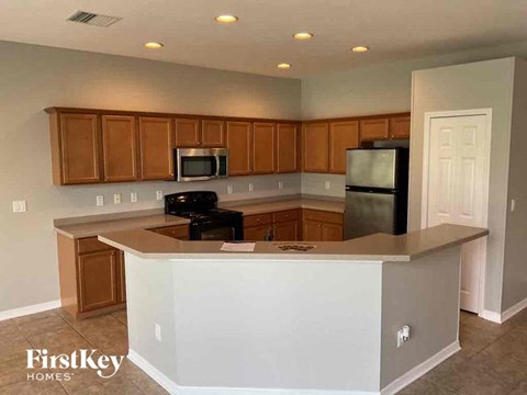 A kitchen with a white island and wooden cabinets.