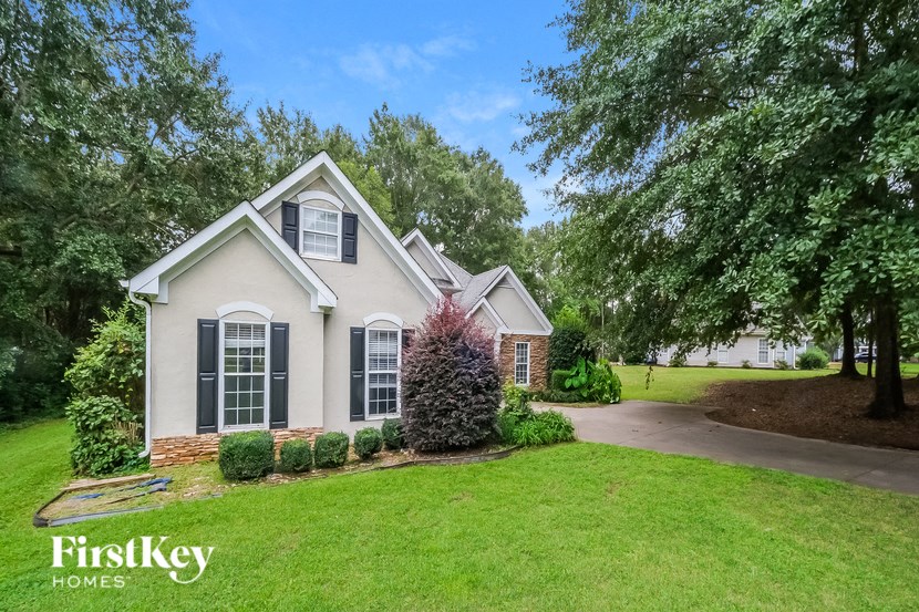 a home with a lawn and trees and a driveway