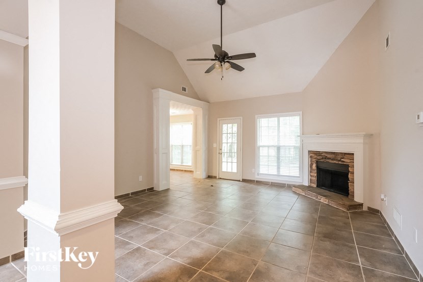 a clean living room with a fireplace and tiled flooring