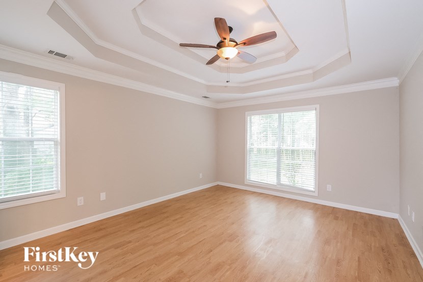 an empty living room with wood floors and a ceiling fan