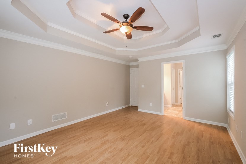 a living room with wood floors and a ceiling fan