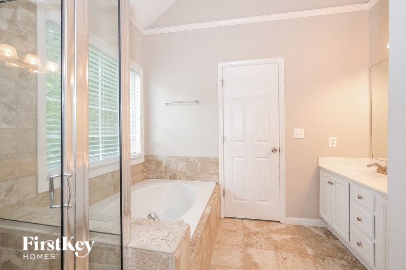 a bathroom with a tub and a shower and a sink